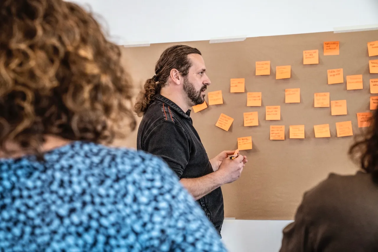 Teilnehmer bringen Events auf eine Modell-Wand an