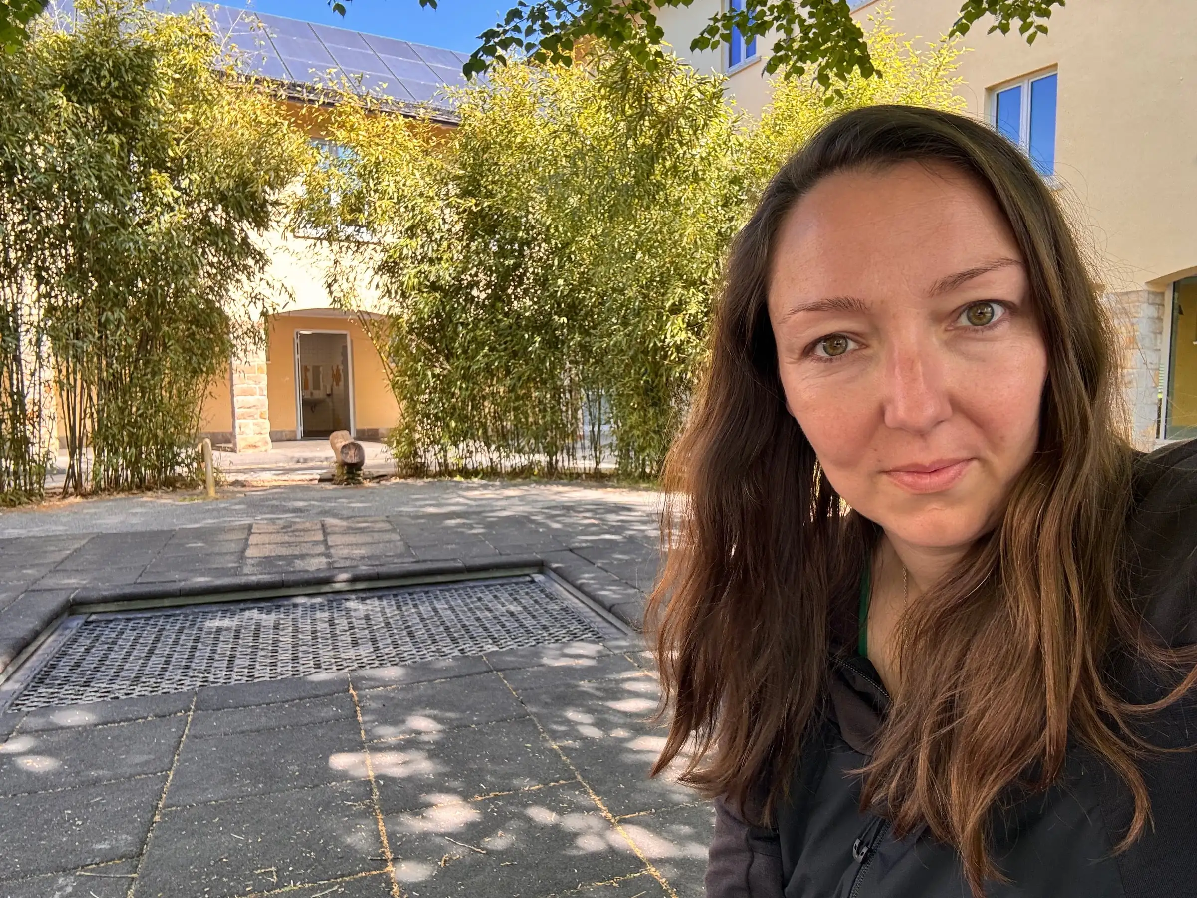 Kathi Asel in einem sonnigen Innenhof mit Bambus